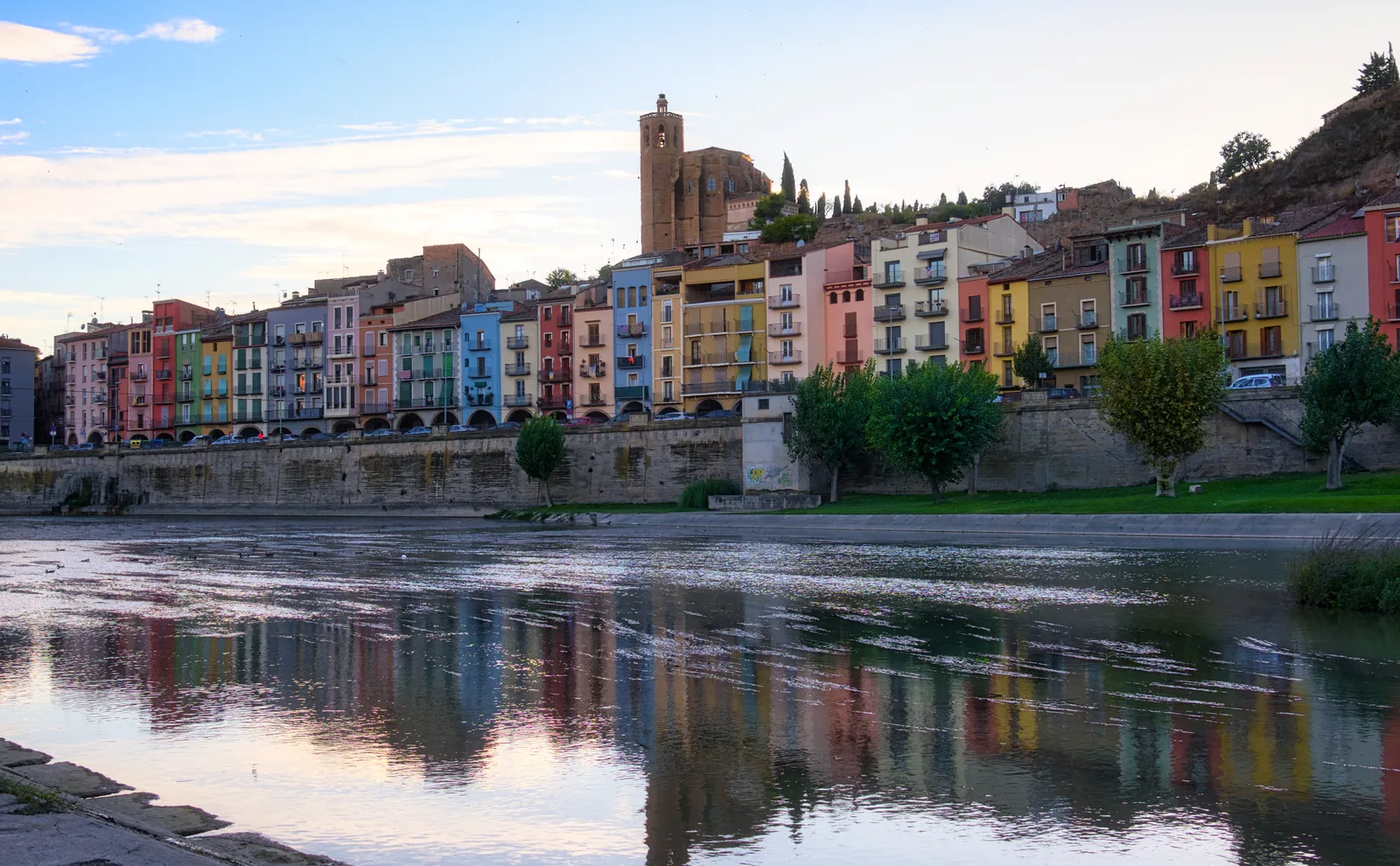 The colourful houses of Balaguer reflected in the river Segre