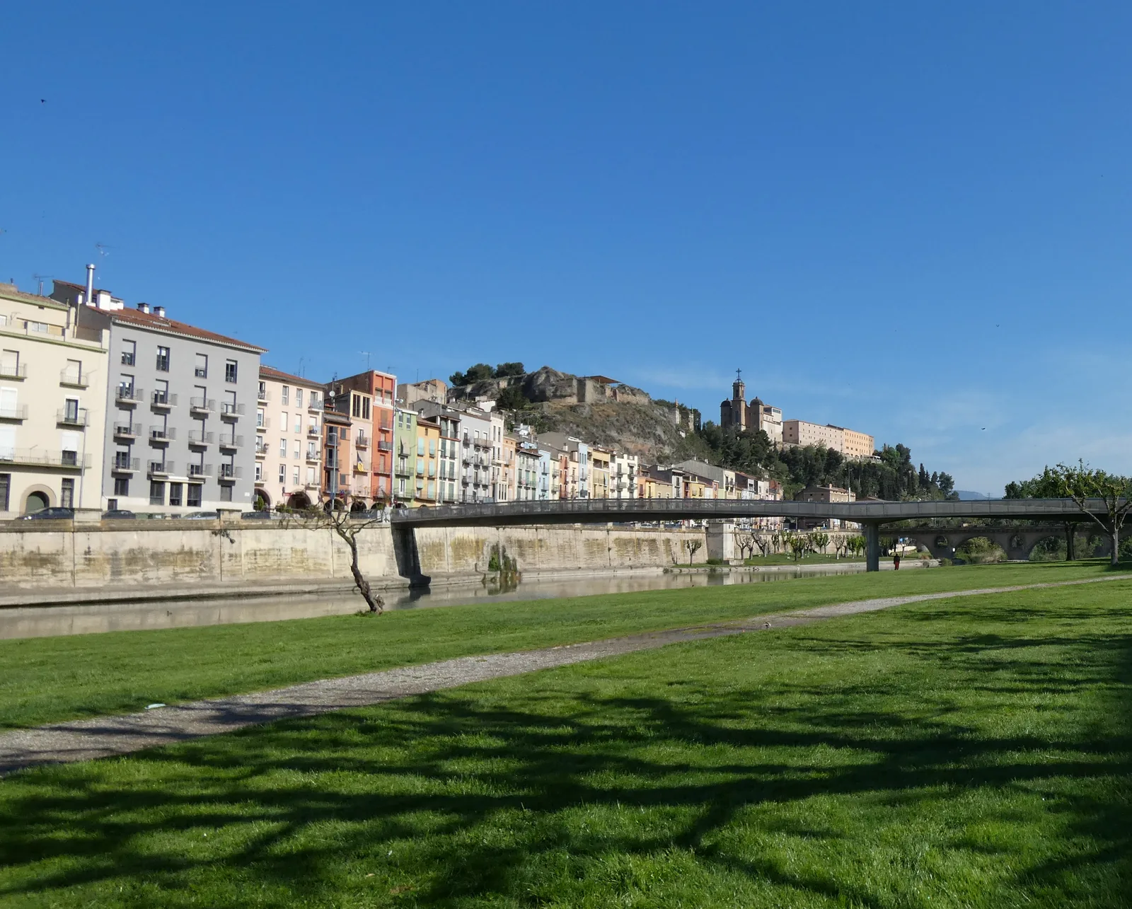 The riverside park by the Segre, with the colourful houses of Balaguer and the castle behind